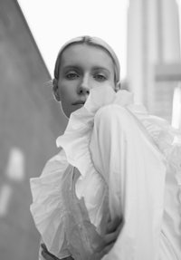 a black and white photo of a woman in a white dress