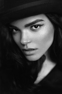 a black and white photo of a woman wearing a hat