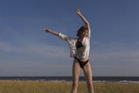 a woman in a bikini standing on a beach