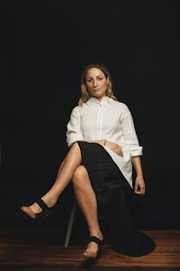 a woman in a white shirt sitting on a chair