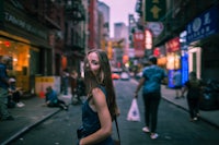 a woman is standing on a street in an asian city